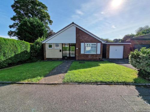 a brick house with a garage and a yard at Free Parking Home In Gatley by City SuperHost in Baguley