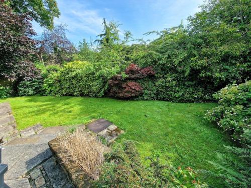 a yard with green grass and bushes at Free Parking Home In Gatley by City SuperHost in Baguley