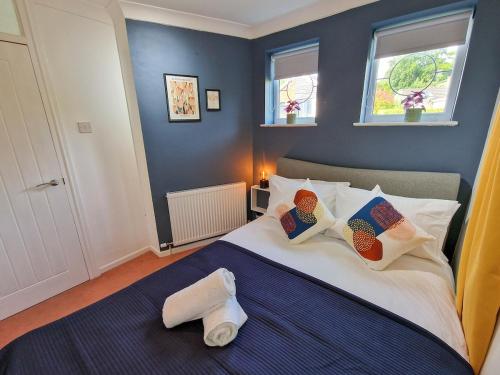 a bedroom with a bed with blue walls and windows at Free Parking Home In Gatley by City SuperHost in Baguley