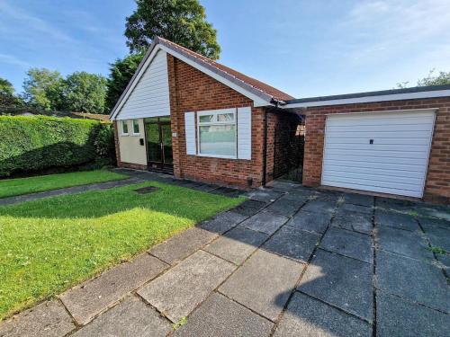 a brick house with a garage and a driveway at Free Parking Home In Gatley by City SuperHost in Baguley
