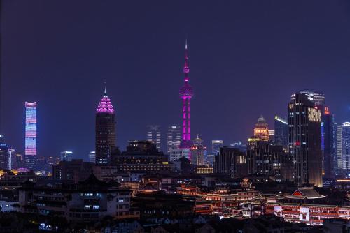 a lit up city at night with tall buildings at Book and Bed - Yuyuan Garden in Shanghai