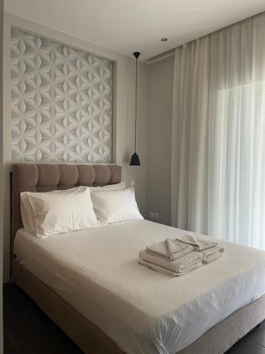 a bedroom with a large bed with a large headboard at Lydia Apartment in Vonitsa