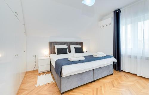 a bedroom with a large bed with blue and white sheets at Nice Home In Stubicke Toplice in Stubicke Toplice
