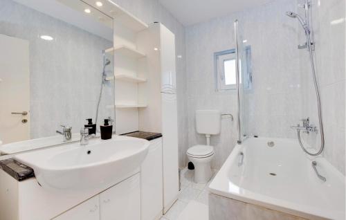 a white bathroom with a sink and a shower at Nice Home In Stubicke Toplice in Stubicke Toplice