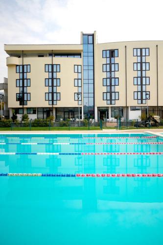 a swimming pool in front of a building at Kona Hotel Verona by Kleos Group Collection in Negrar