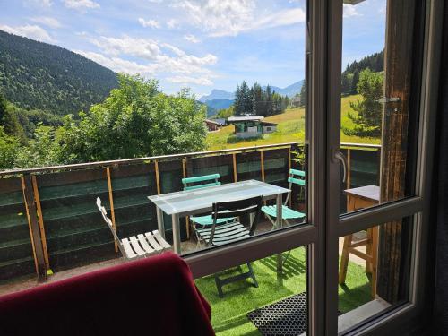 a room with a table and chairs on a balcony at Appartement Col de l'Arzelier in Château-Bernard
