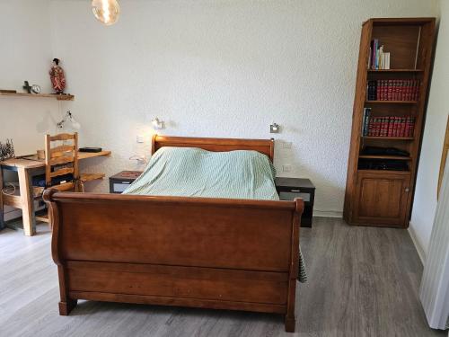 a bedroom with a bed and a book shelf at Appartement Col de l'Arzelier in Château-Bernard