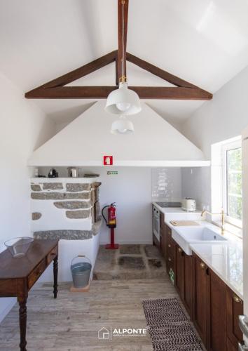 a kitchen with a ceiling fan and a sink at Quinta da Costeira - Casa Azul do Limoal by ALPONTE in Arcos de Valdevez