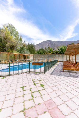 a swimming pool with a fence next to a patio at Hotel Naturaleza Vertientes de Elqui in El Molle