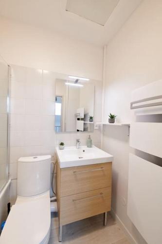 une salle de bain blanche avec des toilettes et un lavabo dans l'établissement Le Duplex Horizon Travot Vue Splendide et Central, à Cholet