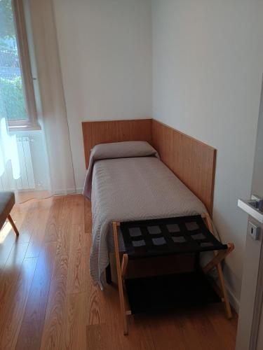 a small bedroom with a bed and a wooden floor at Da Mary in Badia Prataglia