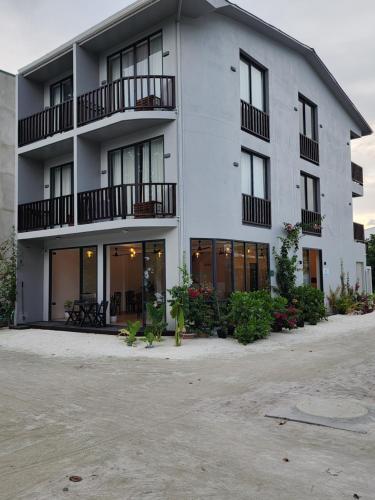 a large white building with windows and balconies at Nikabliss Dhigurah in Dhigurah
