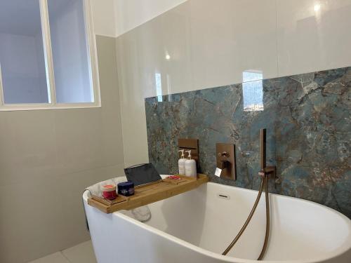 La salle de bains est pourvue d'une baignoire avec un ordinateur portable. dans l'établissement T2 ville et bord de mer, à Ajaccio