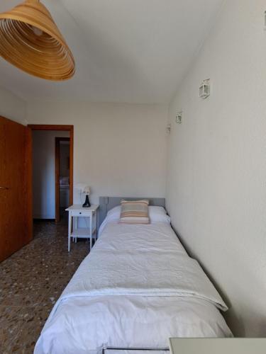 a large bed in a room with a table at "Cal Tu" in San Fausto de Campcentellas