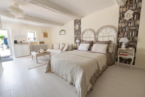 a white bedroom with a large bed and a couch at Cocon de Morgon in Villié-Morgon