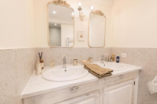 a bathroom with two sinks and a mirror at Cocon de Morgon in Villié-Morgon