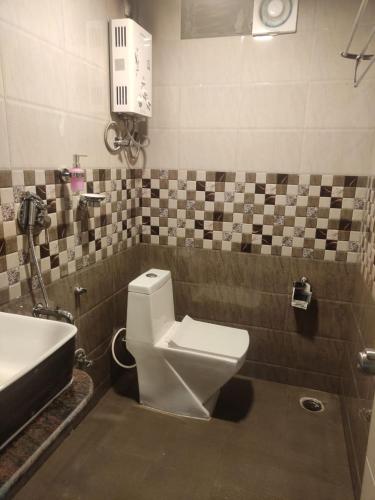 a bathroom with a toilet and a sink at The Mountain Shades Resort in Madikeri