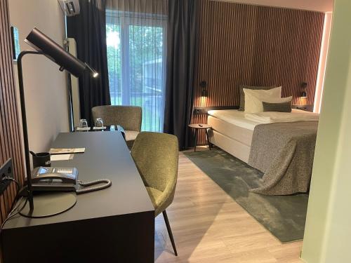 a hotel room with a bed and a desk with a lamp at Schlosshotel Monrepos in Ludwigsburg