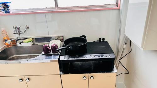 a pot on top of a stove in a kitchen at ゲストハウスROOASiS常磐町501 in Takamatsu