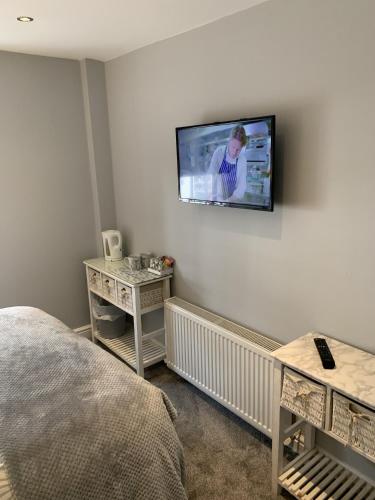 a bedroom with a flat screen tv on the wall at Blackbull With Rooms Lower in Cumbernauld
