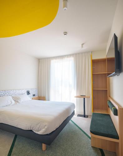 a hotel room with a bed and a tv at Hôtel AKENA Strasbourg - Hoerdt in Hoerdt