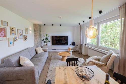 una sala de estar con un sofá y una mesa en Großes Apartment, Top-Lage, See & Berge, Sauna, en Winterberg