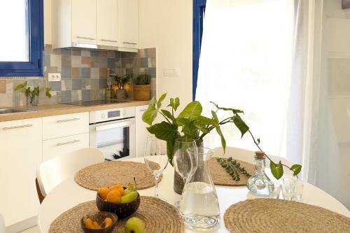 a white kitchen with a table with fruit on it at Blue White House in Tourlotí