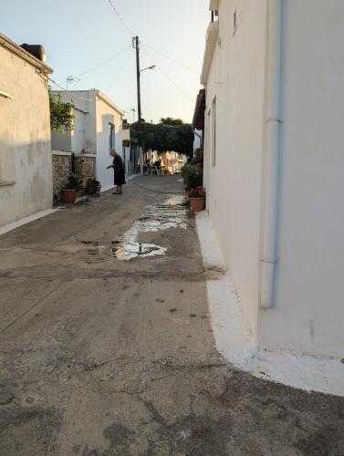 an alley with a person walking down a street at Blue White House in Tourlotí