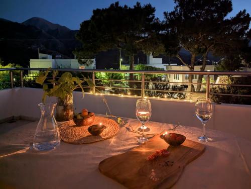 a table with two wine glasses and a plate of food at Blue White House in Tourlotí