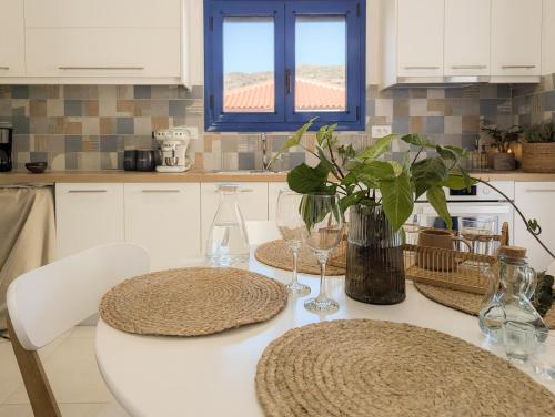 a kitchen with a table with two chairs and a window at Blue White House in Tourlotí