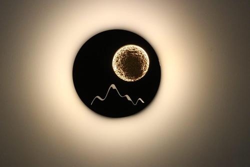 a yellow moon in a black circle with mountains at Domus Mamurra in Formia