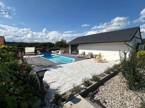 a backyard with a swimming pool and a house at Koniec Świata domek z basenem in Mikołajki