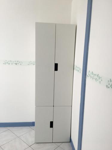 une armoire blanche dans une pièce avec un miroir dans l'établissement Épices au cœur du centre ville historique de Serignan, à Sérignan