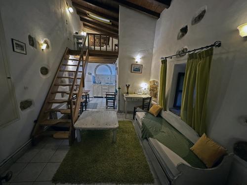 a room with a staircase and a couch and a table at Porfyrousa Traditional Hotel in Milopótamos