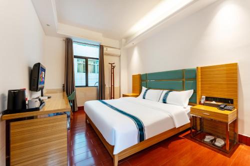 a bedroom with a large bed and a television at 锦泰酒店--广州市十三行南方大厦国际电子城店 in Guangzhou