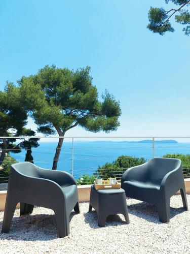 - deux chaises et une table avec vue sur l'océan dans l'établissement Maisonnette vue mer, à Carqueiranne