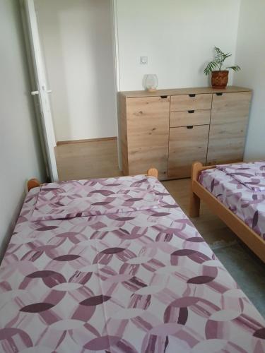a bedroom with a purple bed and a dresser at Apartmani Bubamara Leskovac in Leskovac