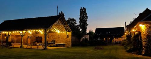 a lit up yard with a building with lights at Wisteria Gites in Saint-Denis-de-Gastines