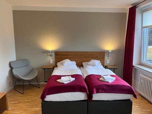 a bedroom with two beds with red and white blankets at Hotel Damme in Damme