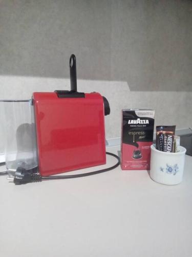 a counter top with a red toaster and a book at ΘωΜΑΙΣ in Glykadi