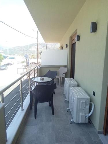a balcony with chairs and a table and a table and chairs at ΘωΜΑΙΣ in Glykadi