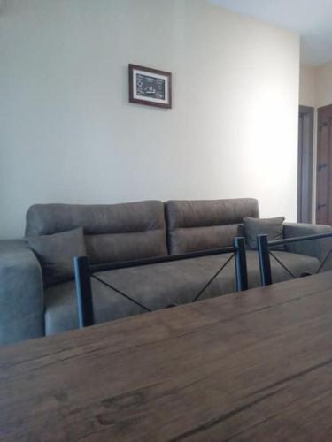 a living room with a couch and a wooden table at ΘωΜΑΙΣ in Glykadi