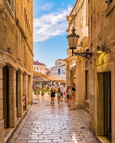 a group of people walking down a street at Calma Luxury Rooms in Split