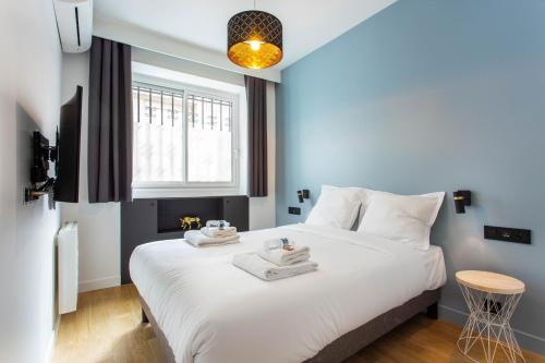une chambre avec un grand lit blanc avec deux serviettes dessus dans l'établissement Magnificent apartment - 2BR-6P - Republique, à Paris
