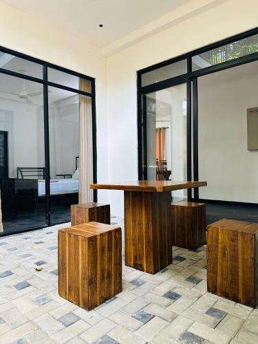 a room with a table and two wooden stools at Large 4 Bedroom Spacious Apartment in Nugegoda, Colombo in Nugegoda