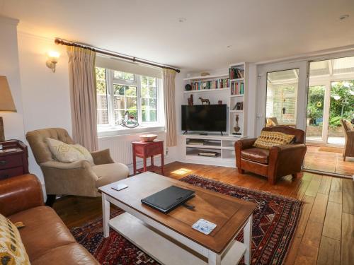 a living room with a couch and a tv at Woodend Annexe in Slindon