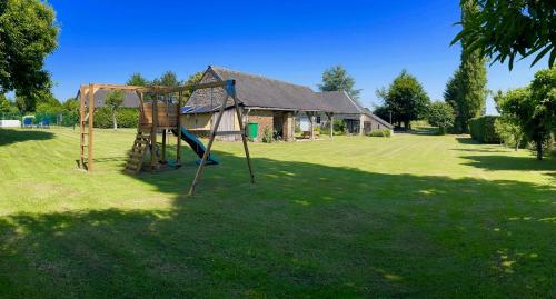 a park with a swing set in the grass at Wisteria Gites in Saint-Denis-de-Gastines