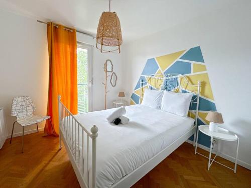 - une chambre avec un lit blanc et une tête de lit colorée dans l'établissement Le Bruxelles 21 - Appartement pour 4 personnes Disneyland Paris, à Montévrain