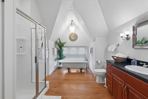 a bathroom with a tub and a toilet and a sink at The Uplifting Mansion in Milwaukee
