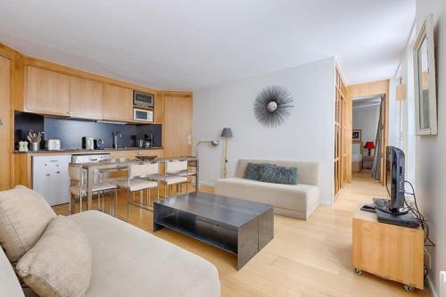 un salon avec un canapé et une table dans l'établissement Luxury Apartment Saint Honore Champs Elysees, à Paris